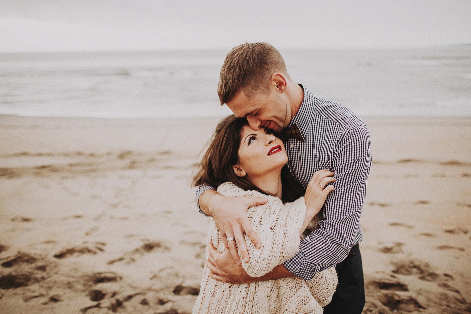 Monterey moody cloudy beach engagement session. California ocean engagement session in red dress