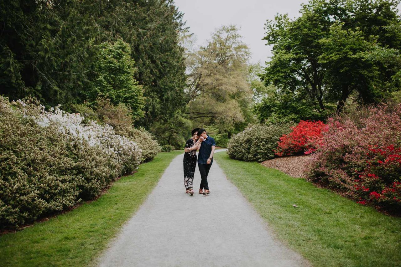 Beautiful same sex couple in spring engagement session with cherry blossom in Seattle Arboretum